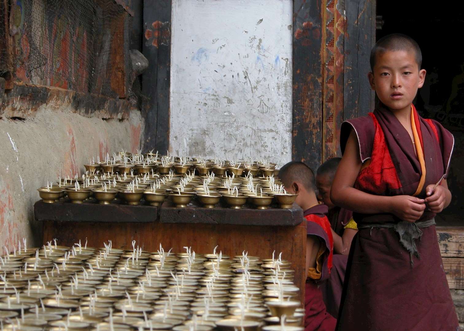 Boy monk next to butterlamps, Jakar Boy monk next to butterlamps, Jakar