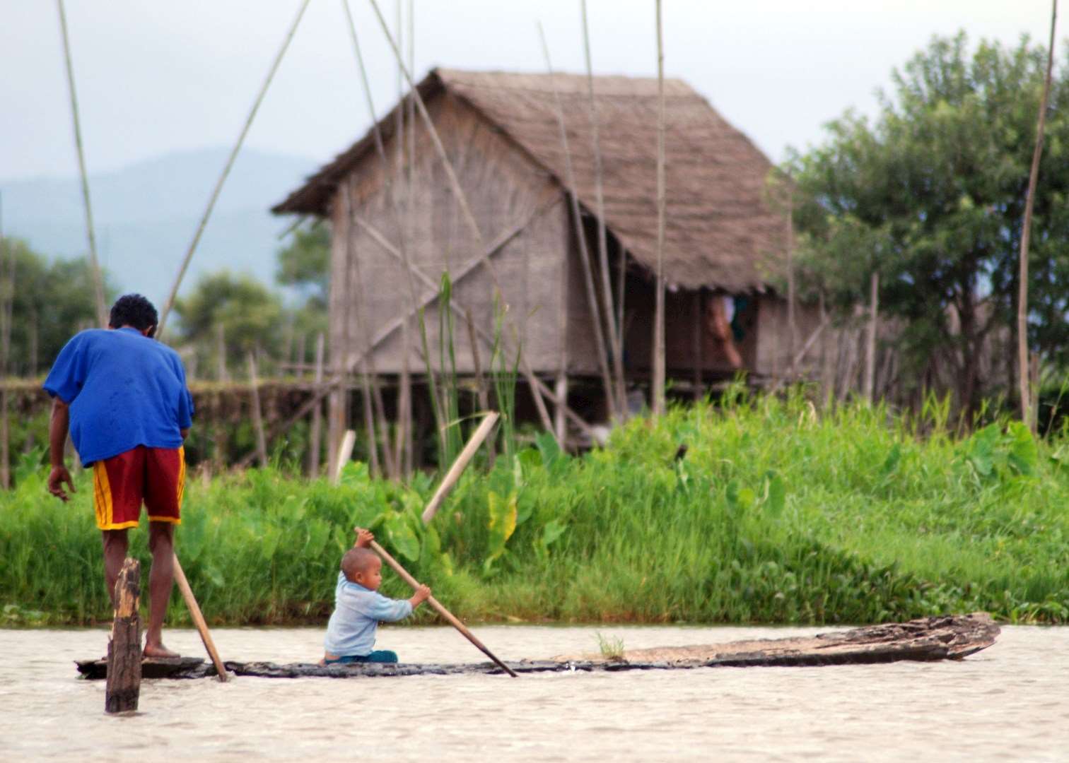 Father and son paddle on their home-made boat, Inle Lake