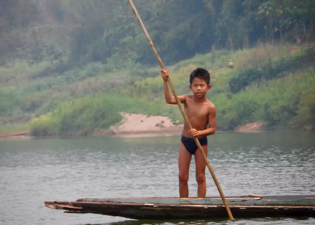 A Fisherman Is Throwing A Fishing Net Into The Mekong River In Luang  Prabang, Laos.