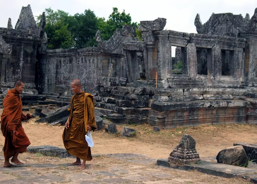 Buddhist monks walk alongside the central sanctuary at Preah Vihear