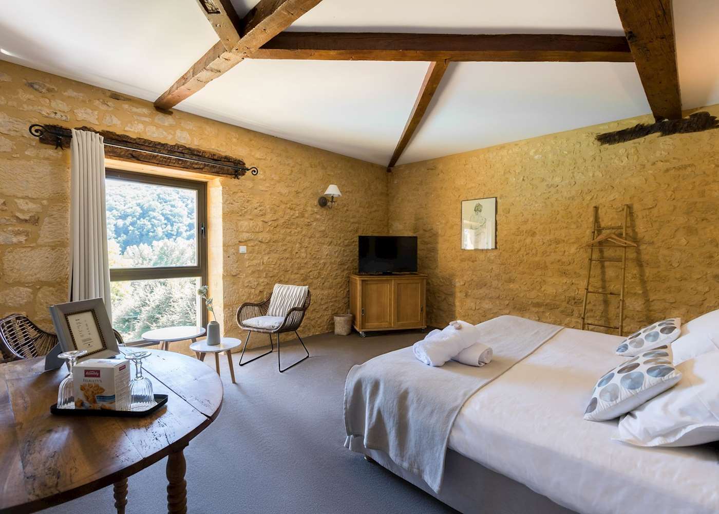 Elegant empty French countryside hotel room with stone walls and wooden beams