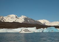 A tourist boat in front of icebergs on Lago Argentino A tourist boat in front of icebergs on Lago Argentino