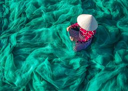 Fisherman repairing nets in Hoi An