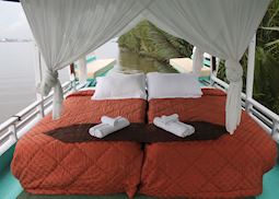 Upper deck double bed on Deluxe Klotok Boat