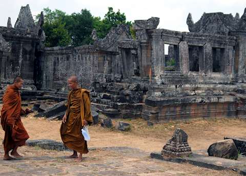 Buddhist monks walk alongside the central sanctuary at Preah Vihear Buddhist monks walk alongside the central sanctuary at Preah Vihear