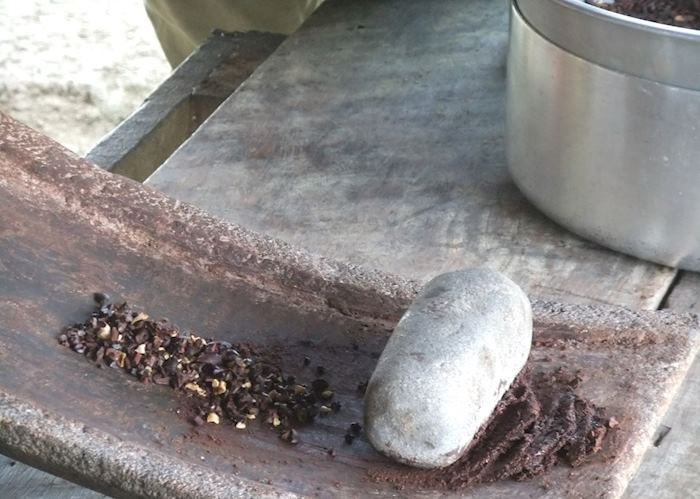 Grinding cacao beans on a metate