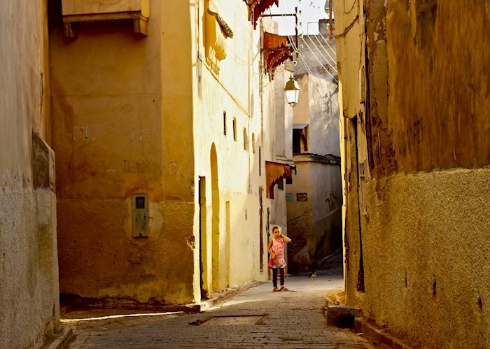 A little girl gazes down the cobbled streets of the ancient medina in Fez