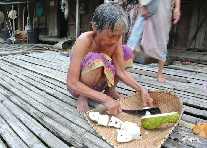 Lady preparing fruit at the Lemanak Longhouse