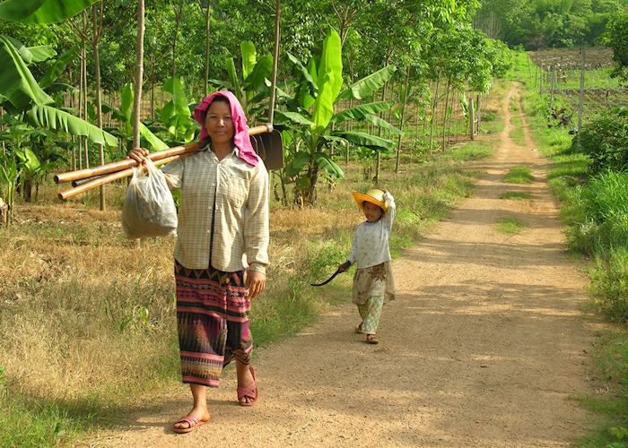 A woman and her daughter return from tending their crops