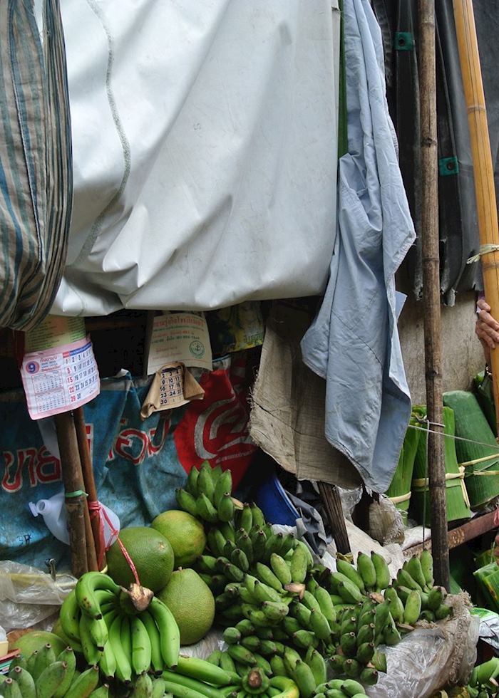 Lady putting up her stall in a market on the railway tracks in Amphawa