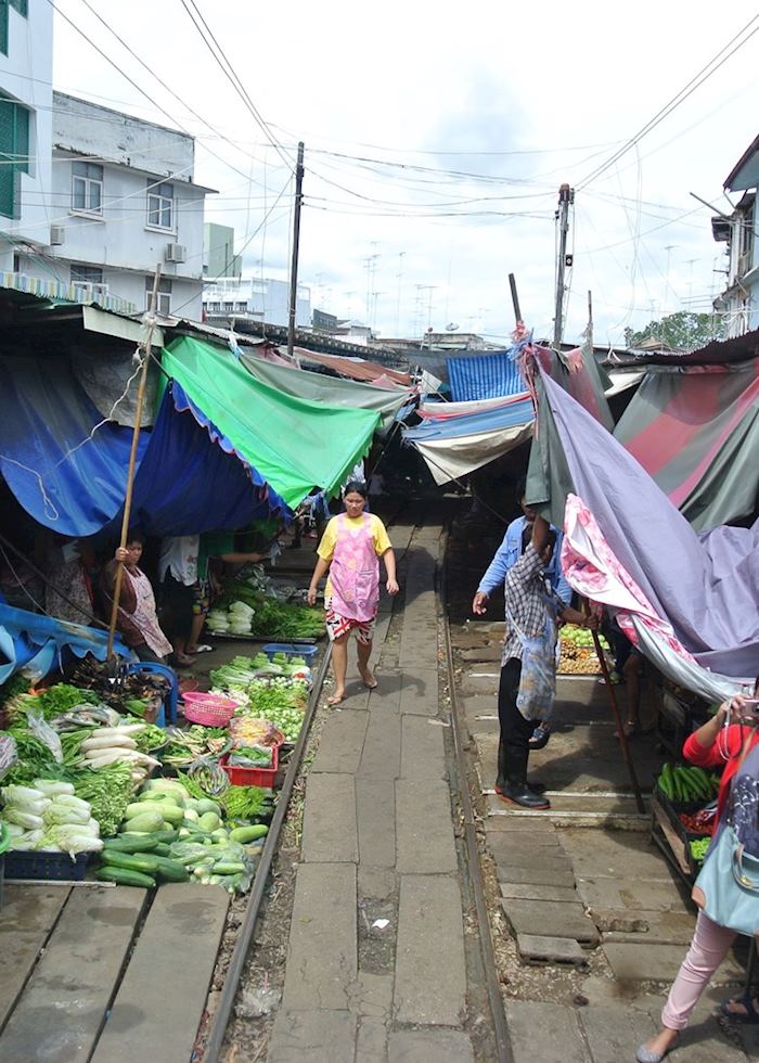 The art of reassembling market stalls on the railway track in Amphawa