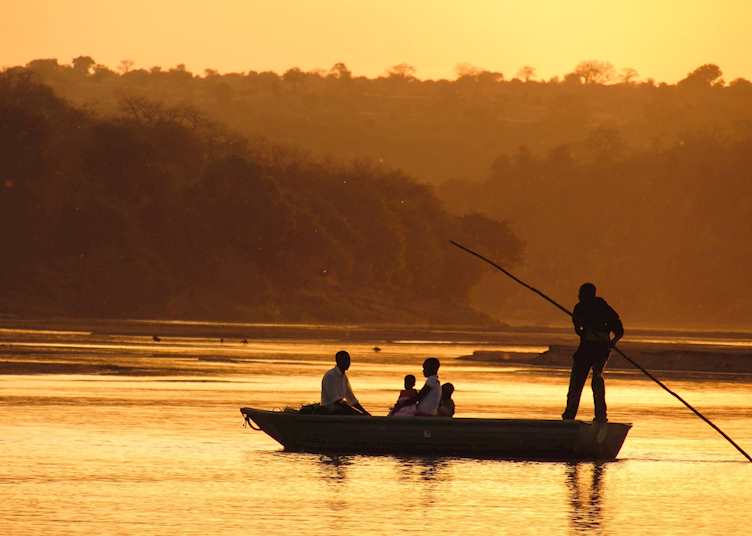 A park ranger takes his family home over the river, Gonarezhou National Park, Zimbabwe