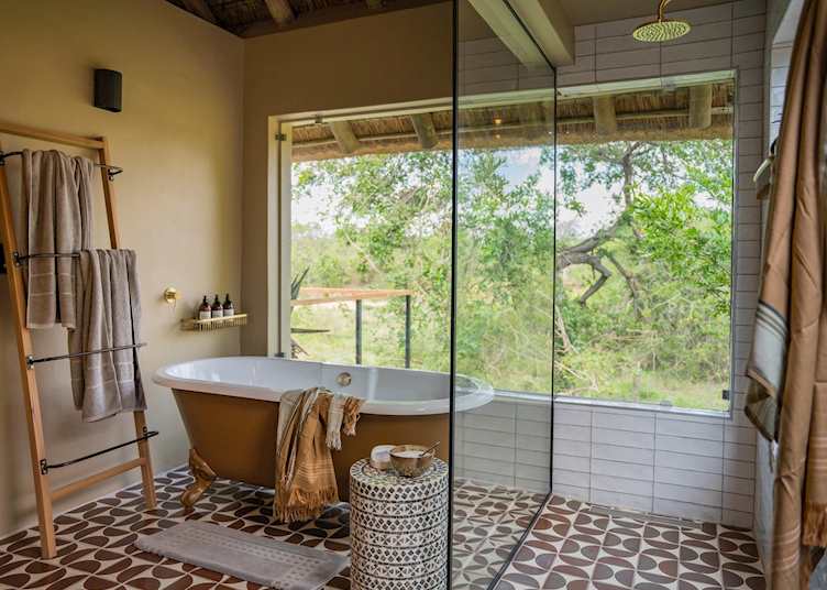 Bathtub and shower in a Luxury Suite at Thornybush Game Lodge