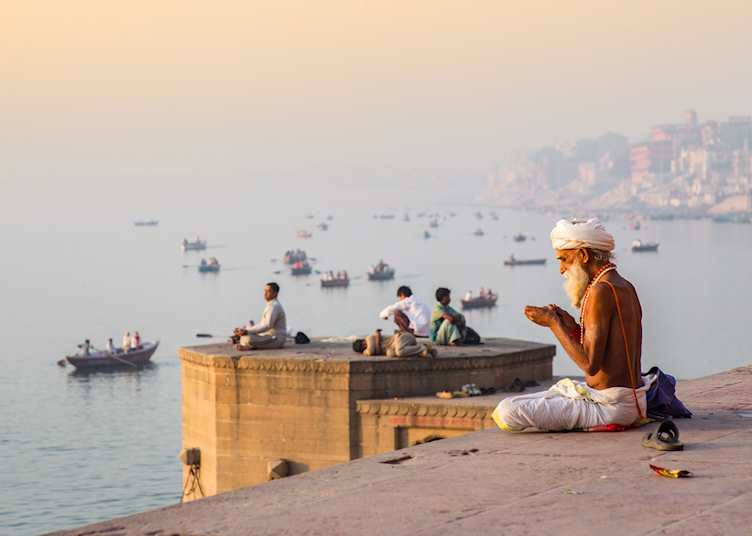 Man doing morning prayer by the river Ganges, Varanasi