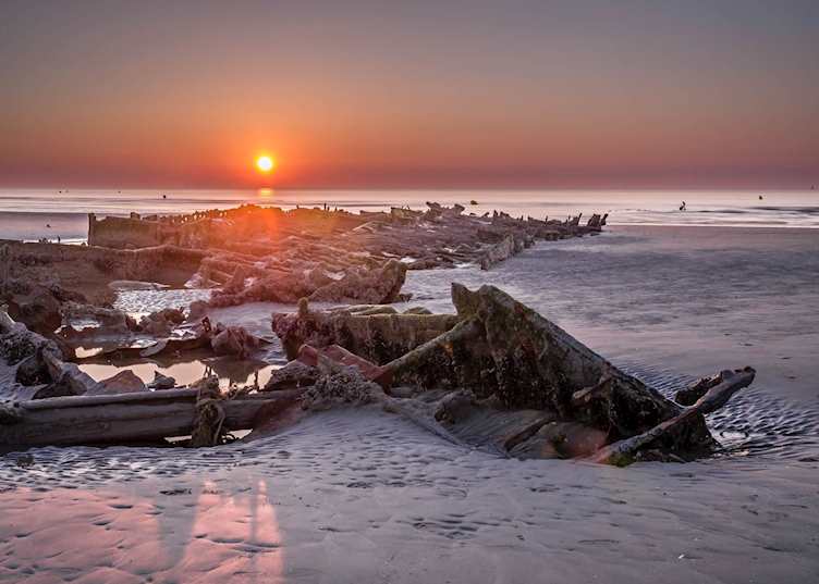 Sunset with exposed shipwreck Crested Eagle from World War II