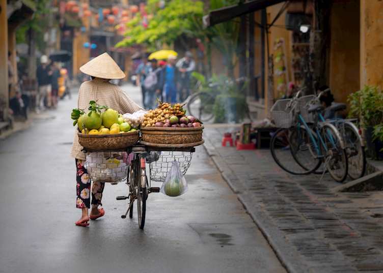 Fruit seller walking along a Hoi An street