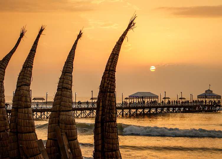 Reed boats on Huanchaco Beach at sunset