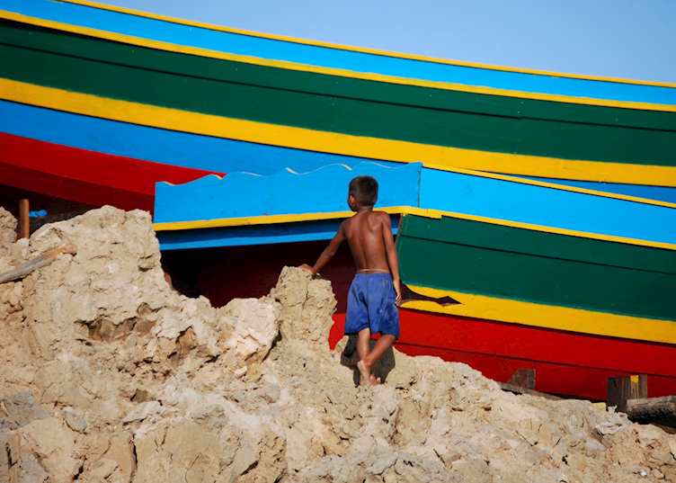 Young boy exploring the freshly painted boats - Tonle Sap