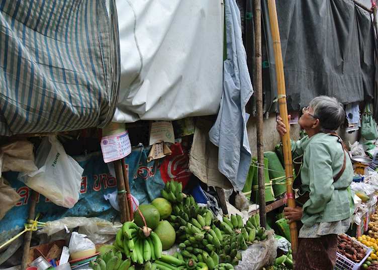 Lady putting up her stall in a market on the railway tracks in Amphawa