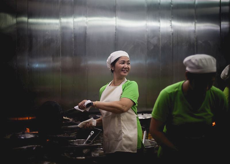 Woman cooking in an open kitchen in downtown Saigon