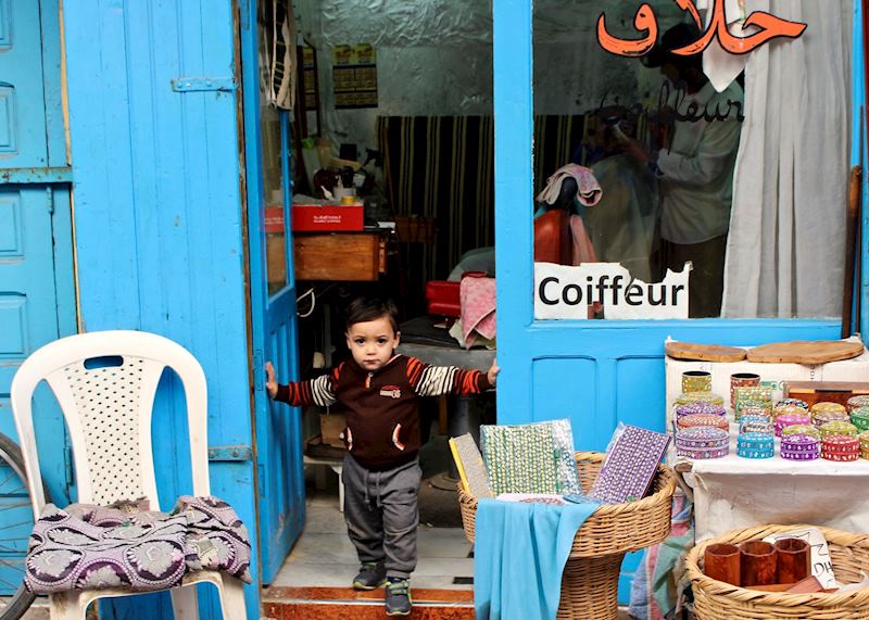 Boy in barber's shop doorway