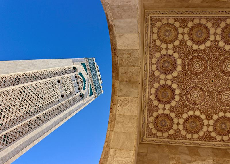 The stunning minaret of the Hassan II Mosque looms over a carved archway