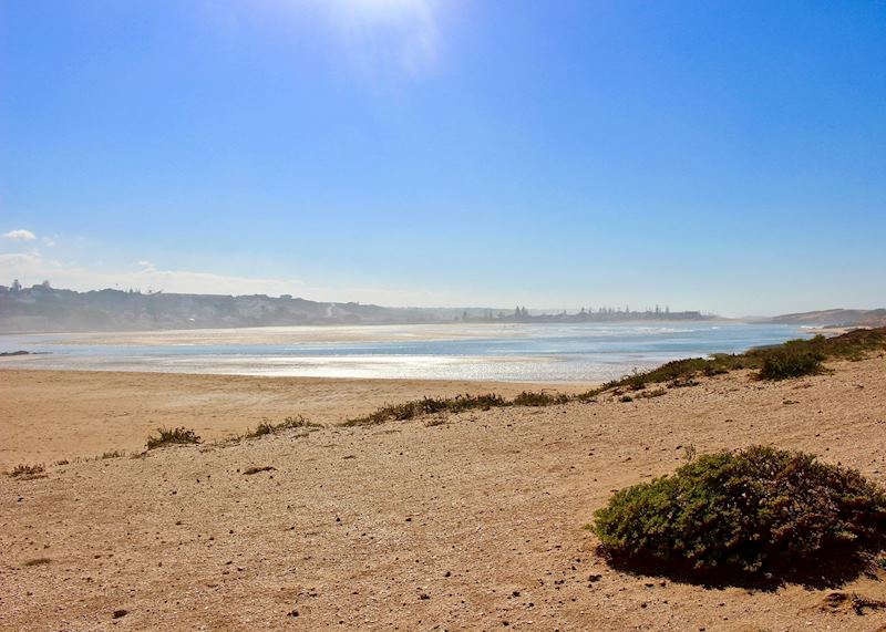 Oualidia's port shines in the distance, reflecting the midday sun.