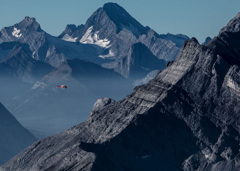 Helicopter passing through mountains in Canmore
