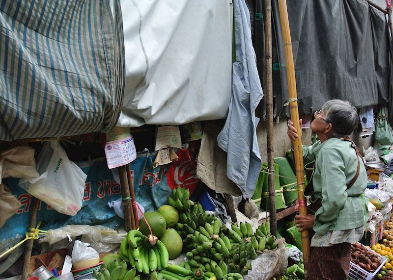 Lady putting up her stall in a market on the railway tracks in Amphawa